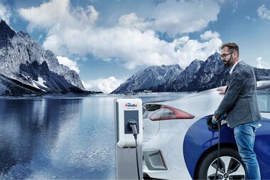 vkw vlotte Vorarlberg | © vkw vlotte Vorarlberg Mann der sein Elektroauto an einem See an einer Ladesäule auflädt | © vkw vlotte Vorarlberg