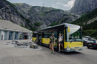 Green Ticket Lünersee - Dein klimafreundlichster Weg zum Lünersee | © Golm Silvretta Lünersee Tourismus GmbH Bregenz, Philipp Schilcher Ein Mann und eine Frau die gerade auf dem Parkplatz vor der Lünerseebahn aus dem Bus aussteigen | © Golm Silvretta Lünersee Tourismus GmbH Bregenz, Philipp Schilcher