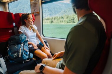 Zwei Personen die im Zug sitzen und aus dem Fenster hinausschauen | © Golm Silvretta Lünersee Tourismus GmbH Bregenz, Philipp Schilcher