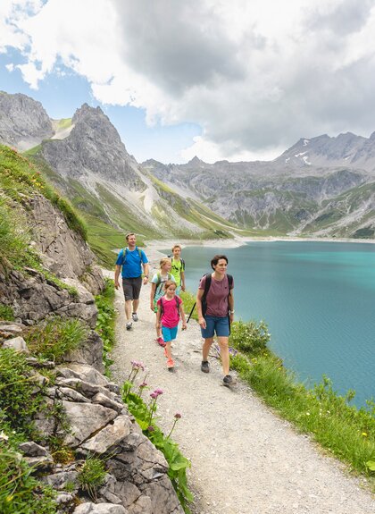Familie, die gerade um den Lünersee wandert | © Golm Silvretta Lünersee Tourismus GmbH Bregenz, Stefan Kothner