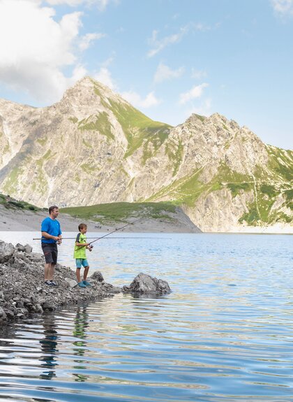 Vater mit Sohn, die gerade am Lünersee fischen | © Golm Silvretta Lünersee Tourismus GmbH Bregenz, Stefan Kothner